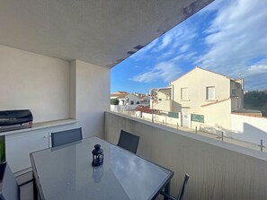 Enjoy the view from this balcony with a glass-top table and grill.