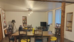 A dining area with a wooden table and chairs, a bookshelf, a lamp, and a television. - House with enclosed garden in Villabon (Villabon)