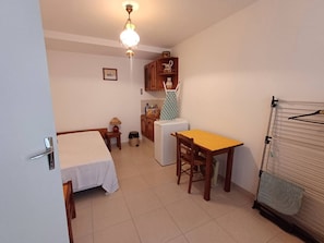 Cozy retreat with a single bed, kitchenette, and compact dining area.