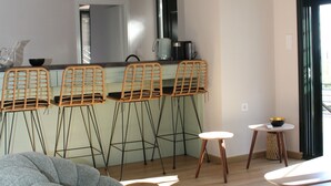 Une cuisine moderne avec des tabourets de bar, une table ronde et un fauteuil en forme de poire.