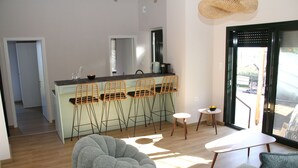 Une cuisine moderne avec des tabourets de bar, une table à manger et une grande fenêtre.
