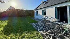 A modern house with a stone patio and a grassy yard. - Carnac House 4 Rooms, Garden, Pets Allowed (Carnac)