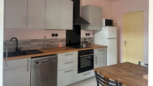 A modern kitchen with stainless steel appliances, a wooden countertop, and a built-in oven. - The Sorbier house, Provence (Maillane)