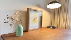 A wooden table with a framed picture and a vase of dried flowers. - The Sorbier house, Provence (Maillane)