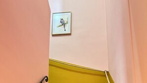 A staircase with green steps, a yellow handrail, and a framed picture on the wall. - The Sorbier house, Provence (Maillane)