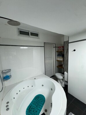 Banheira de hidromassagem, toalhas de banho, sabonete, papel higiênico