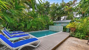 A poolside area with lounge chairs and a small building with a sign. - ~CONCH COTTAGES~ Enjoy your next island vacation with friends right here! (Key West)