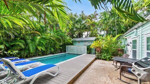 A pool area with lounge chairs and a barbecue grill. - ~ROYAL POINCIANA COTTAGE~ Come and indulge yourself in some KW sunshine! (Key West)