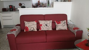 Un sofá rojo con cojines estampados en una cocina moderna.
