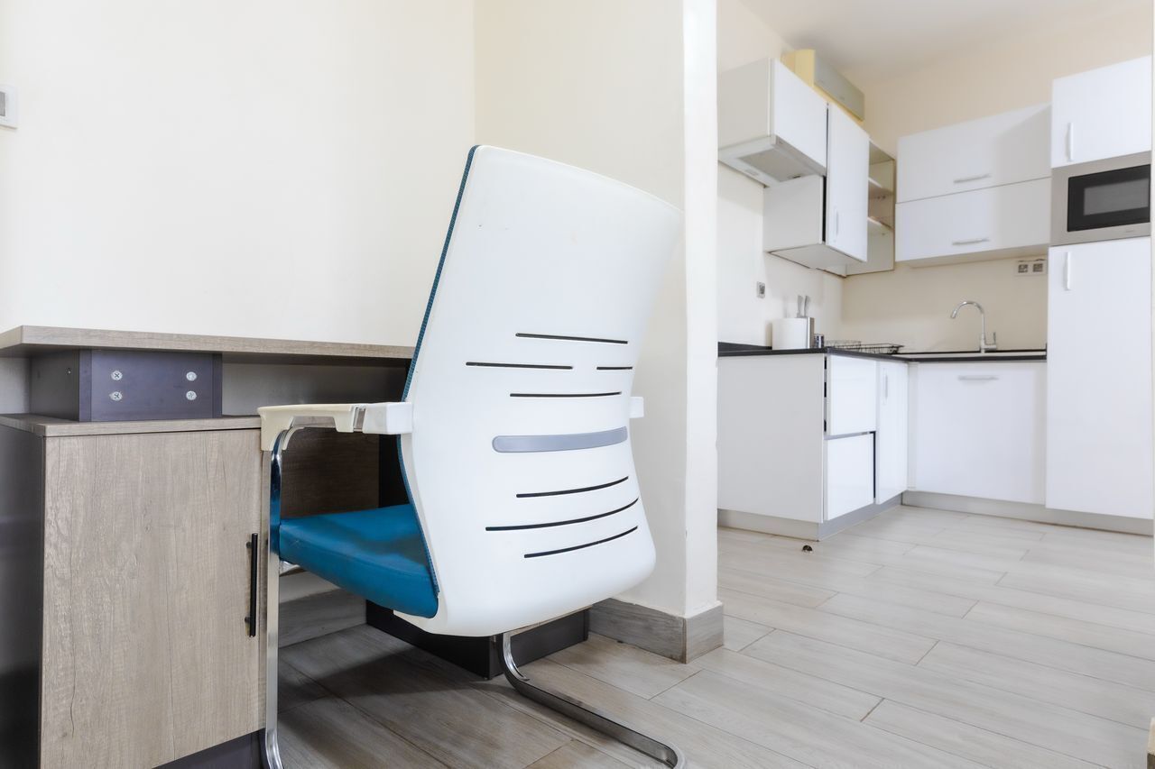A modern kitchen with white cabinets, a microwave, and a sink.