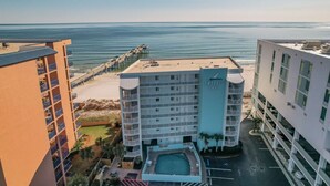 A hotel with multiple floors, a pool, and a beach view.