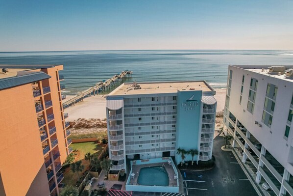 A hotel with multiple floors, a pool, and a beach view.