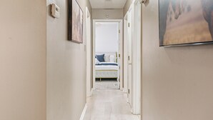 A narrow hallway with a bed at the end, a ceiling light, and a framed picture on the wall. - The Bourbon Trail Bungalow Ping Pong/Foosball/Bar/Firepit (Mount Washington)