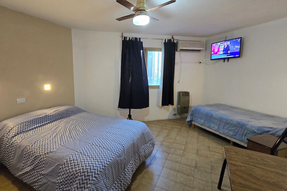 Cubrecamas, espacio para trabajar con laptop y cortinas blackout