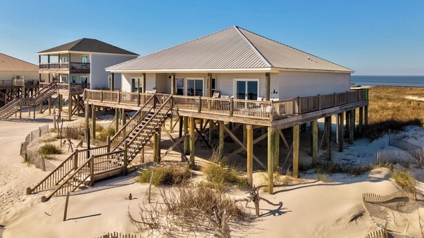 A beachfront house with a wooden deck and stairs leading to the main building. - "Wahoo" Gulf Beachfront, 4 Bedroom/4 Bath, Sleeps 14, Pet Friendly, Cargo Lift (Dauphin Island)