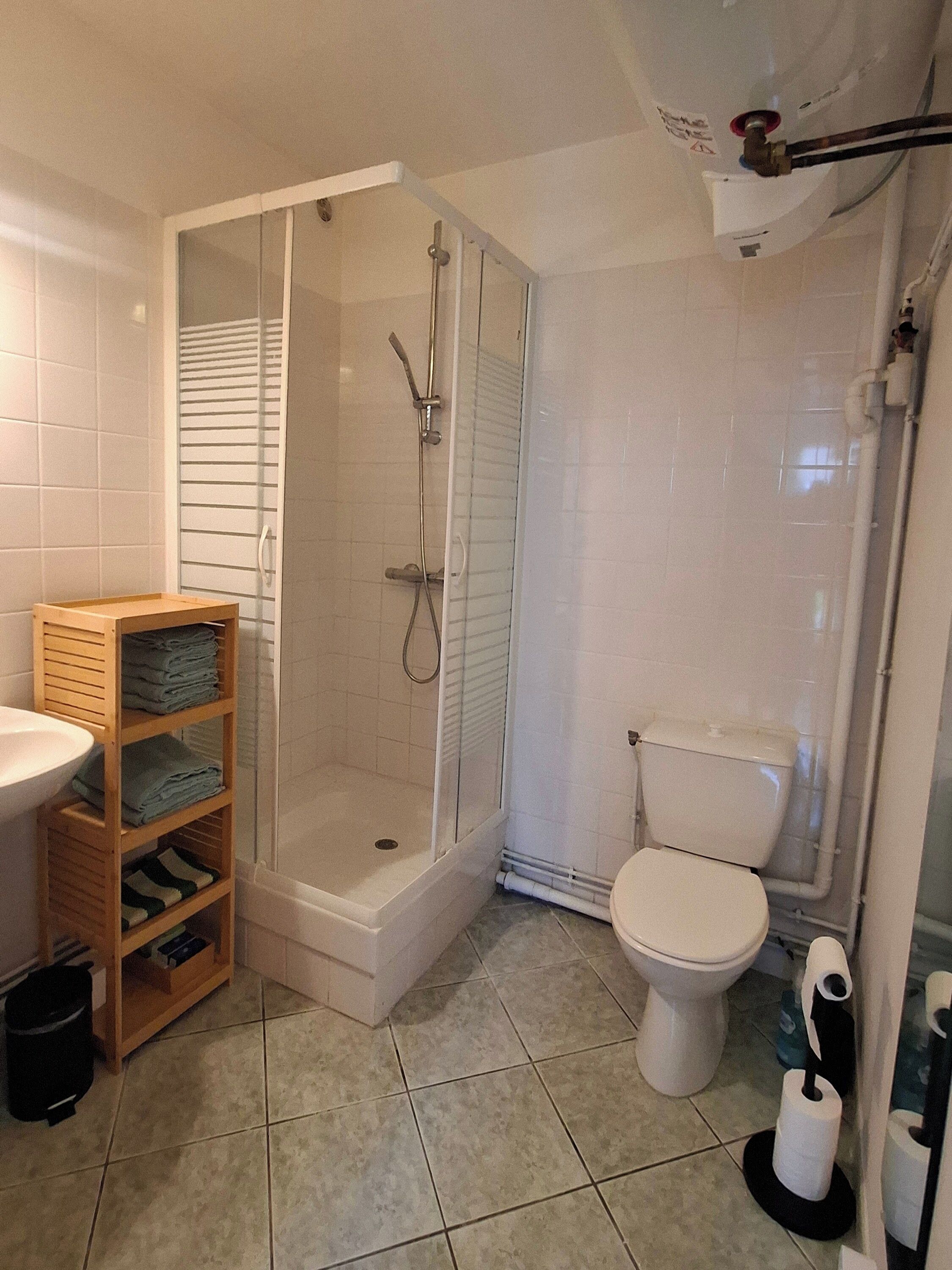 Un baño con ducha envuelta en vidrio, inodoro y lavabo.
