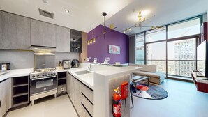 Een moderne keuken met een centraal eiland, inbouwapparatuur en een groot raam met uitzicht op de stad.
