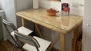 A compact kitchen with a refrigerator, microwave, and a small table with a chair. - Posillipo - panoramic apartment in the heart of the sea of Naples (Napoli)