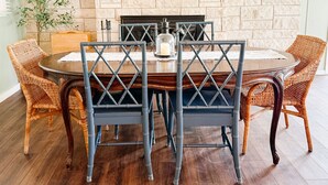 A dining area with a brick fireplace, a sign reading 'LAKE BOATS CABINS,' and wicker chairs. - Lakefront fun for 14+pets w/game room deck sunsets (Whitney)