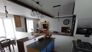 Une cuisine moderne dotée d’un îlot central, de meubles en bois et d’un four à micro-ondes.