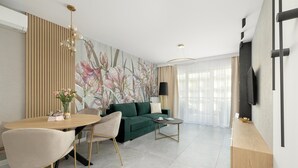 Ein modernes Wohnzimmer mit einem grünen Sofa, einem runden Esstisch und einem minimalistischen Design.