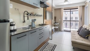 A modern kitchen with grey cabinets, a built-in stove, and a dining area with a table and chairs. - Close to Rio's city center | IM712 (Rio de Janeiro)