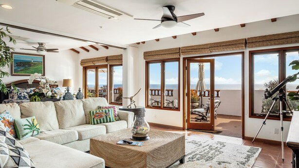 A spacious living room with a large sofa, a coffee table, and a telescope. There are large windows with a view of the ocean. - H1864: Remodeled 2Br villa, AC, 4-seat cart, OCEAN VIEWS, BBQ (Avalon)