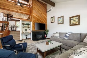 TV connectée, cheminée, livres, chaîne hi-fi