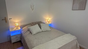A bedroom with a bed, bedside lamps, a nightstand, a wall art piece, and a ceiling light fixture. - House by the river. Near Sarlat, Beynac, La Roque Gageac (Vézac)