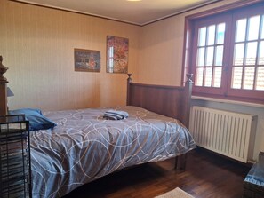 A bedroom with a bed, a radiator, a window, and wall art. - La ca dal Tunec. Monterosa Valley, Relax,adjacent Fenera Park, (Crabia Superiore)