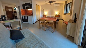A compact living space with a kitchenette, a dining area, and a bed. - Corsican chestnut (Vico)