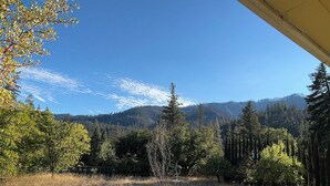A view of a forested area with a house in the foreground and mountains in the background. - Private 1-bedroom 1-bathroom guest suite in the forested area of Trinity County. (Big Bar)