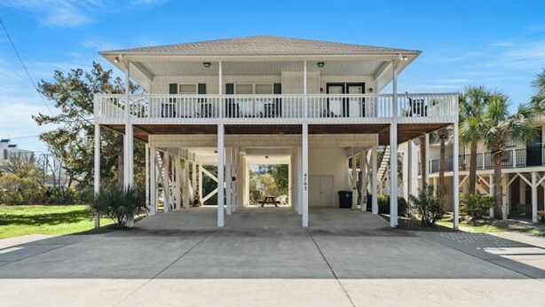 A two-story house with a covered porch and a balcony.