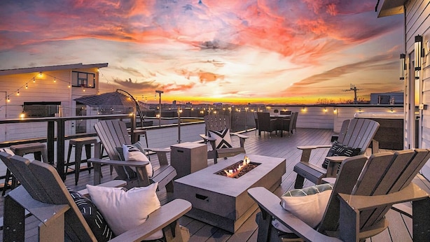 A rooftop patio with outdoor seating, a fire pit, and string lights against a sunset backdrop. - SIDE BY SIDE HOMES - 8 BEDROOMS- 2 HOT TUBS (Nashville)