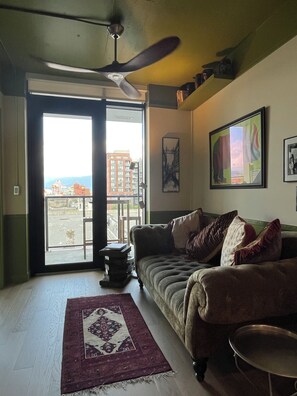 A living room with a sofa, a coffee table, a rug, and a ceiling fan. - Extended stays are well discounted  1 bedroom apartment NOT an IKEA showroom! (Vancouver)