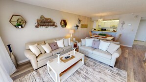 A living room with two sofas, a coffee table, and decorative wall art. - Stunning 1st floor 2 bed w/beach service (Miramar Beach)