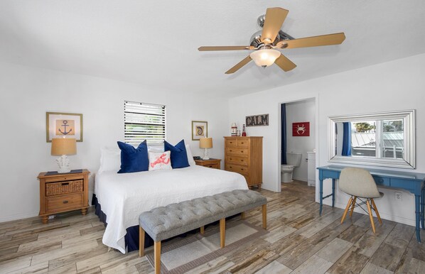A bedroom with a bed, a desk, a chair, a ceiling fan, and a window. - 🏖️Private Pool, Steps to Beach-Times Square District-Lazy Lobster🦞 (Fort Myers Beach)