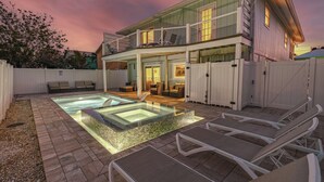 A two-story house with a glass-enclosed patio, a swimming pool, and outdoor seating. - 🏖️Private Pool, Steps to Beach-Times Square District-Lazy Lobster🦞 (Fort Myers Beach)