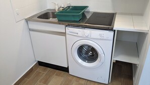 A compact laundry room with a washing machine and a sink. - Quiet apartment - furnished (Rouen)