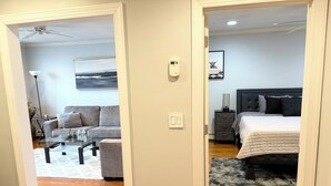 A modern bedroom with a bed, bedside table, and a nightstand.