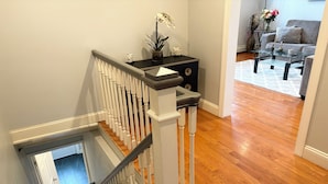 A staircase with white balusters and a dark handrail leading to a landing.