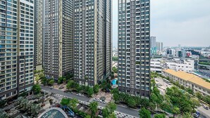 A high-rise building with multiple floors, surrounded by greenery and a road. - Vinhomes Central Park Landmark 81-Apts (Ho Chi Minh City)