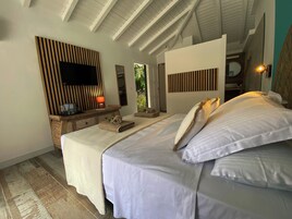 Un dormitorio con una cama, una mesita de noche con lámpara, un espejo y un panel de pared de madera.