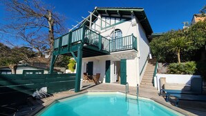 A two-story building with a pool, a balcony, and a staircase leading to the upper floor. - Spacious house with garden and pool (Arcachon)