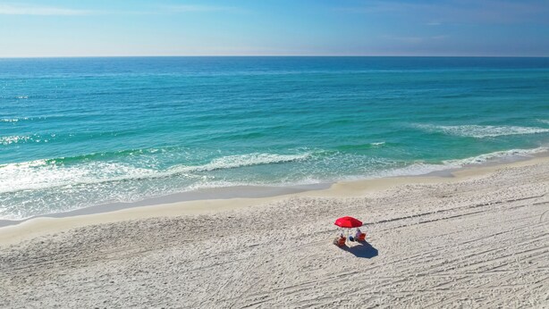 A beach with a red umbrella and two people sitting on chairs. - Close to 2 Beach Accesses, Resort Pool, Bikes, Gulf View (Inlet Beach)