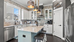 A modern kitchen with white cabinetry, a granite island, and stainless steel appliances. - Close to 2 Beach Accesses, Resort Pool, Bikes, Gulf View (Inlet Beach)