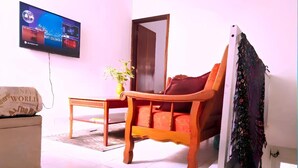 Un salon avec un canapé, une table basse, un téléviseur et une porte.