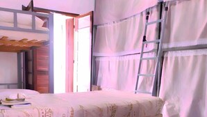 Une chambre à coucher avec un lit, une échelle et une fenêtre avec des rideaux.