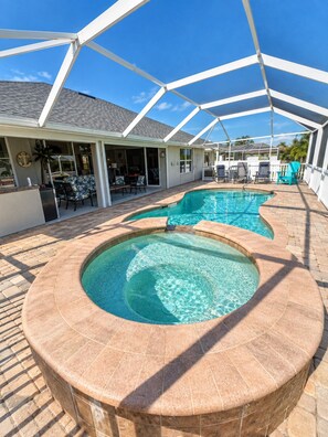 A swimming pool with a hot tub, covered patio, and outdoor seating area. - Villa Pelican Point by swflorida-villas with gulf access  in SW Cape Coral (Cape Coral)