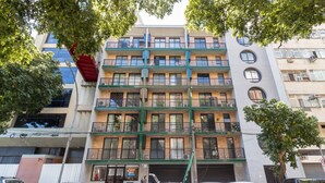 A multi-story residential building with balconies, a visible storefront, and parked cars. - Close to Rio's city center | IM712 (Rio de Janeiro)